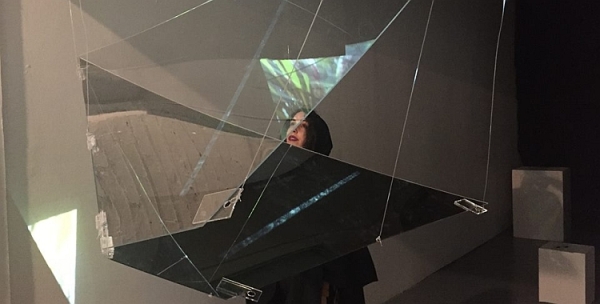 A woman looking into a fractured prism in a gallery